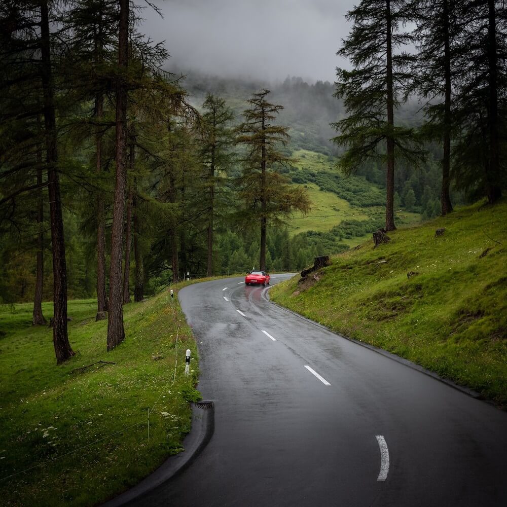 coche en una carretera junto a bosque en suiza 