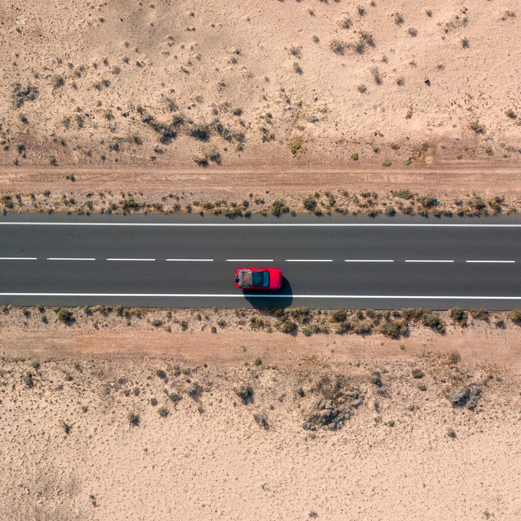 voiture rouge dans les vallées désertiques de l'île de Lanzarote, îles Canaries, Espagne